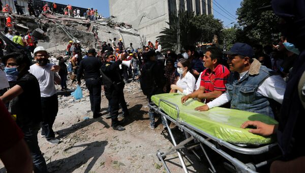 Медработники на месте разрушенного в результате землетрясения здания в Мехико. 19 сентября 2017