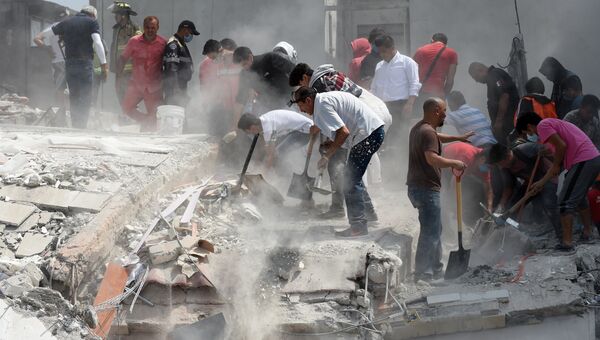 Люди помогают извлекать пострадавших из под обломков здания после землетрясения в Мехико