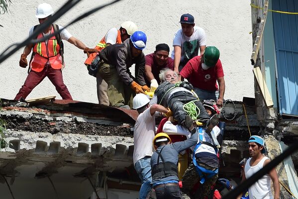 Спасатели вытаскивают пострадавшего из под завалов после землетрясения в Мехико. 19 сентября 2017
