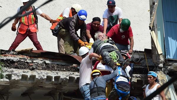 Спасатели вытаскивают пострадавшего из под завалов после землетрясения в Мехико. 19 сентября 2017