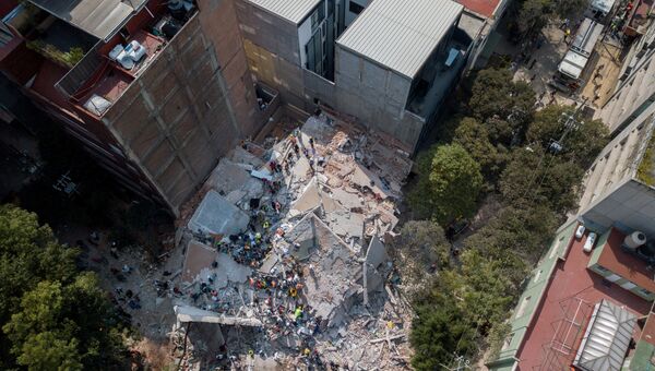 Поисково-спасательная операция на месте разрушенного в результате землетрясения здания в Мехико. 19 сентября 2017