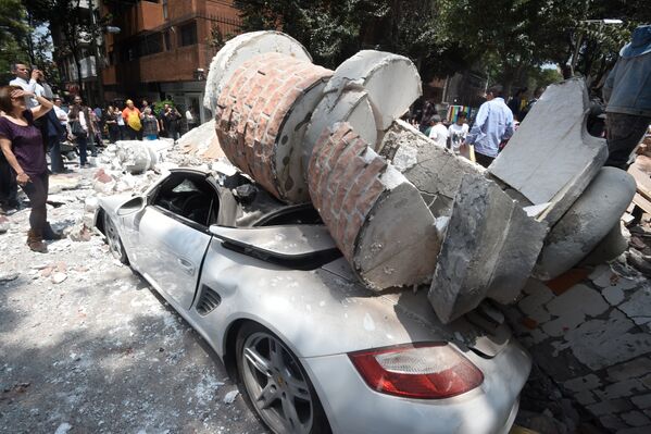 Автомобиль, поврежденный обломками рухнувшего здания, после землетрясения в Мехико. 19 сентября 2017