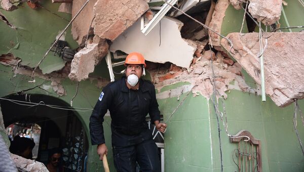 Спасатель ищет выживших после землетрясения в Мехико. 19 сентября 2017