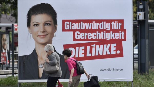 Женщины проходят мимо предвыборного плаката с кандидатом от Левой партии в Берлине