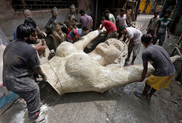 Ремесленники несут женскую скульптуру во время подготовки к индуистскому фестивалю Дурга-пуджа в Калькутте