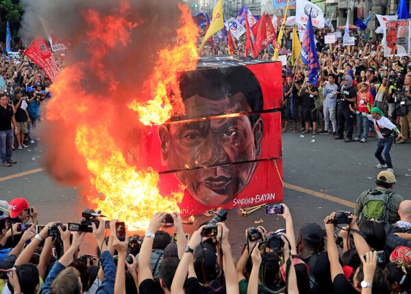 Протестующие сжигают портрет президента Филиппин Родриго Дутерте в Маниле