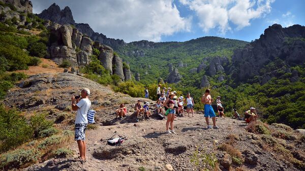 Туристы фотографируются в Долине привидений на горном массиве Демерджи-яйла в Алуштинском регионе Крыма
