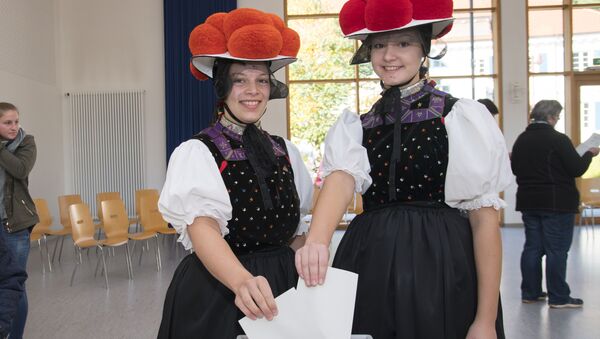 Молодые немки в традиционной одежде региона называемого Черный лес на избирательном участке в Германии. 24 сентября 2017