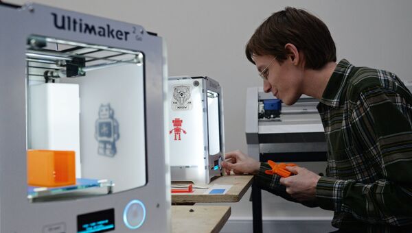 Юноша печатает на 3D принтере
