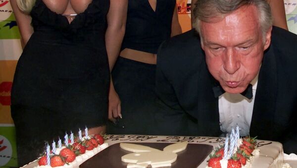 Основатель Playboy Хью Хефнер задувает свечи на свой 75-летний юбилей. 12 мая 2001