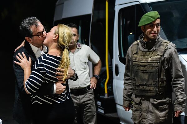 Журналист турецкой оппозиционной газеты Кумхуриет целует свою жену после освобождения из тюрьмы в Стамбуле