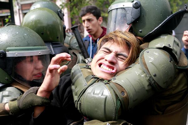 Задержание демонстранта во время студенческого протеста в Чили.