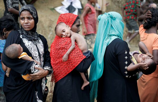 Беженцы рохинджа ждут гуманитарную помощь в лагере в Кокс-Базаре, Бангладеш.