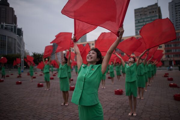 Участники творческого коллектива выступают у центрального железнодорожного вокзала Пхеньяна.