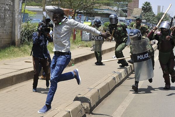Демонстрант убегает от полиции во время акции протеста в Найроби, Кения.