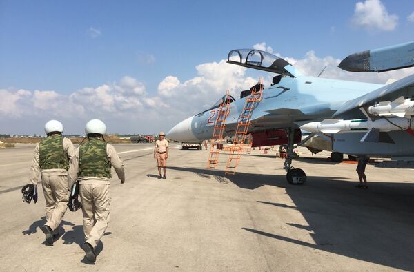 Российские летчики готовятся к посадке в истребитель Су-30 перед вылетом с аэродрома Хмеймим в Сирии Российские летчики готовятся к посадке в истребитель Су-30 перед вылетом с аэродрома Хмеймим в Сирии