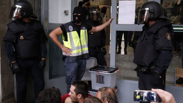 Испанские полицейские захватывают урны для голосования на избирательном участке в Барселоне, Испания. 1 октября 2017