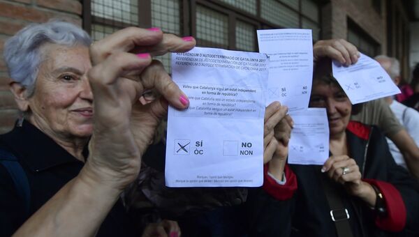 Женщины держат бюллетени на избирательном участке в Барселоне, Испания. 1 октября 2017