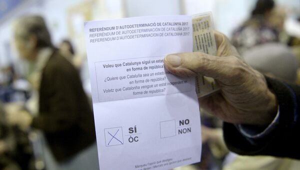 Мужчина держит бюллетень на избирательном участоке в Барселоне, Испания. 1 октября 2017