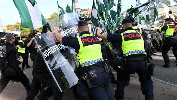 Полицейские останавливают демонстрантов Северного движения сопротивления в центре Гетеборга, Швеция. 30 сентября 2017