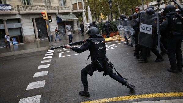 Испанская полиция стреляет резиновыми пулями по людям, пытающимся добраться до места голосования в Барселоне, Испания. 1 октября 2017