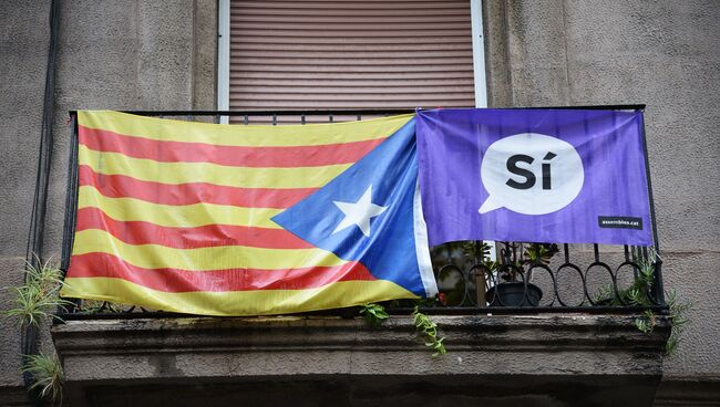 Агитационный плакат и флаг на одном из балконов в Барселоне, где проходил референдум о независимости Каталонии от Испании. 1 октября 2017