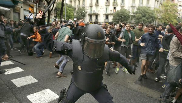 Испанская полиция угрожает дубинкой потенциальным избирателям в Барселоне, Испания. 1 октября 2017