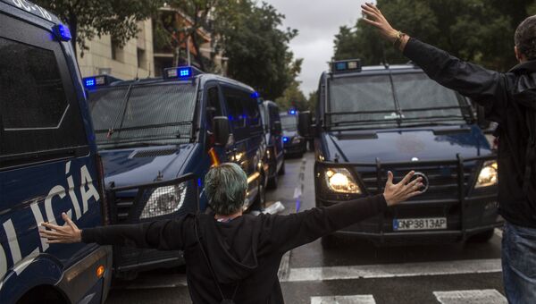 Люди пытаются остановить испанские полицейские фургоны в Барселоне, Испания. 1 октября 2017