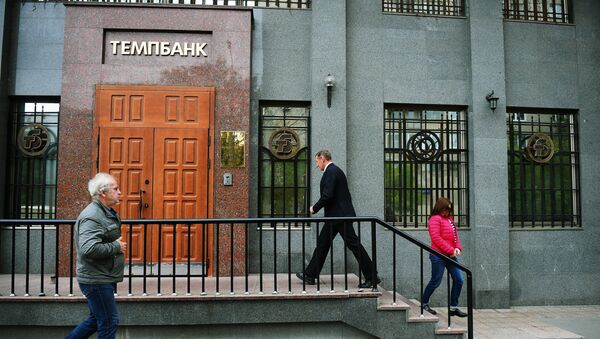 Прохожие у входа в здание Темпбанка в Москве. 2 октября 2017