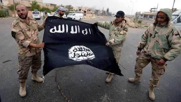 Бойцы сирийского отряда народного ополчения Соколы пустыни демонстрируют флаг Исламского государства (ИГ, запрещена в РФ)