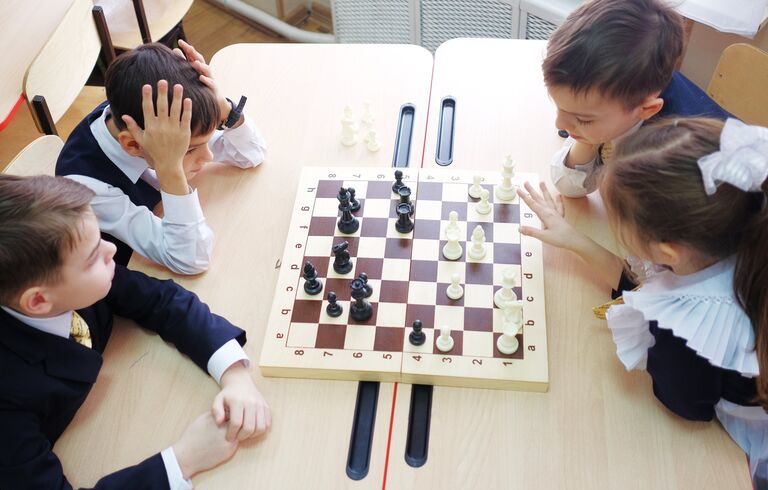 Ученики на практическом занятии по игре в шахматы Ученики на практическом занятии по игре в шахматы