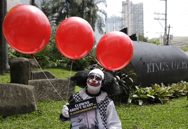 Человек в костюме клоуна во время демонстрации сторонников вегетарианства в Маниле, Филиппины