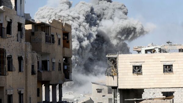 Дым после авиаудара по позициям боевиков в Ракке, Сирия