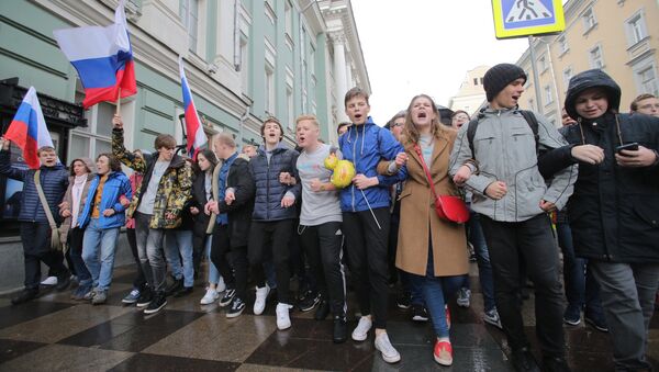 Участники несанкционированной акции протеста идут по улице Малая Дмитровка в Москве. 7 октября 2017