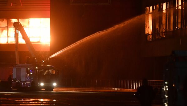 Сотрудники пожарной охраны МЧС РФ во время тушения пожара на строительном рынке Синдика. 8 октября 2017