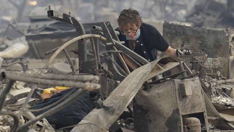 Женщина возле своего сгоревшего дома в Санта-Розе, Калифорния, США. 9 октября 2017