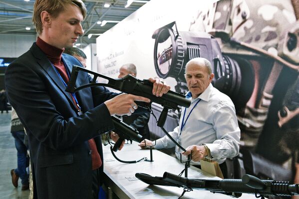 Мужчина осматривает оружие на выставке Оружие и безопасность в Киеве