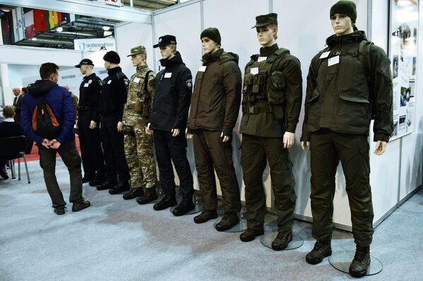 Мужчина осматривает различные модели экипировки, представленные на выставке Оружие и безопасность в Киеве