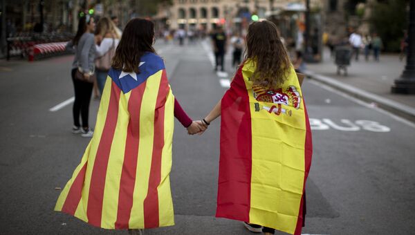 Девушки в флагах Испании и Каталонии во время демонстрации в Барселоне. Архивное фото