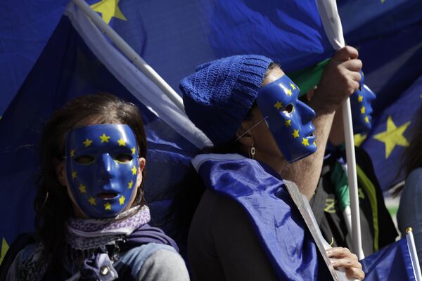 Участники акции протеста против Brexit в масках, стилизованных под флаг Евросоюза, в Лондоне Участники акции протеста против Brexit в масках, стилизованных под флаг Евросоюза, в Лондоне