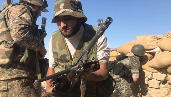 Бойцы сирийской армии во время наступления к востоку от города Дейр-эз-Зор в районе кладбищ. Архивное фото