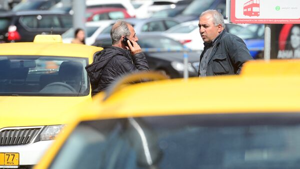Мужчины разговаривают у автомобилей такси. Архивное фото
