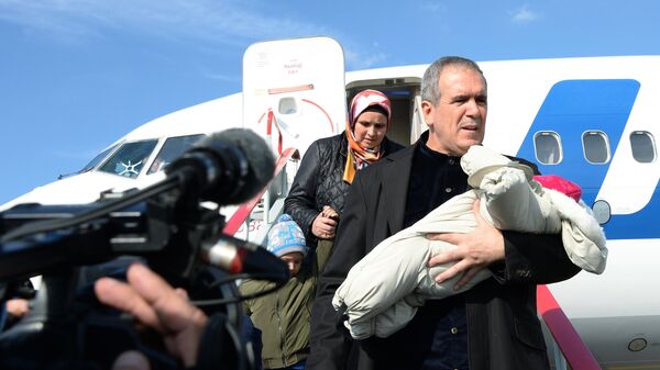 Полномочный представитель Чеченской Республики при президенте РФ Зияд Сабсаби с ребенком, возвращенным из Ирака, в аэропорту Грозного. Архивное фото