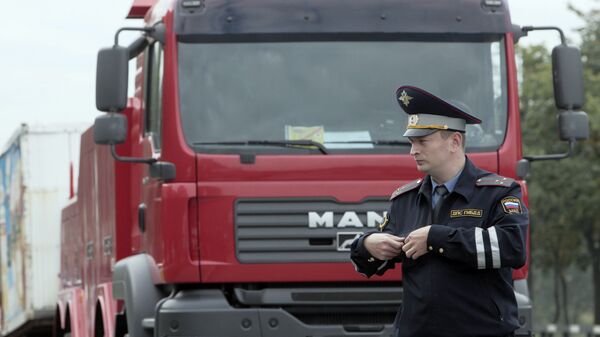Сотрудник ДПС стоит у брошенного грузовика.