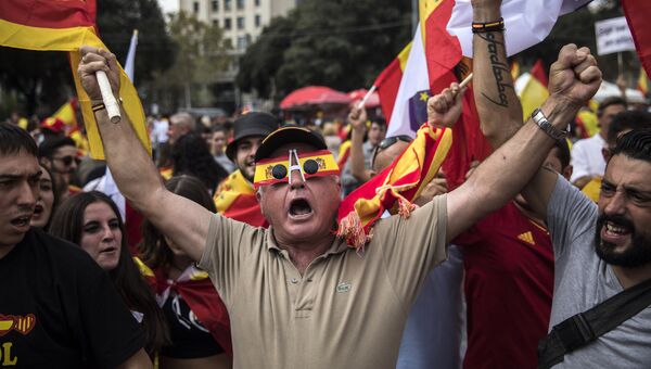 Люди с испанскими и каталонскими флагами во время Национального дня Испании в Барселоне. Архивное фото