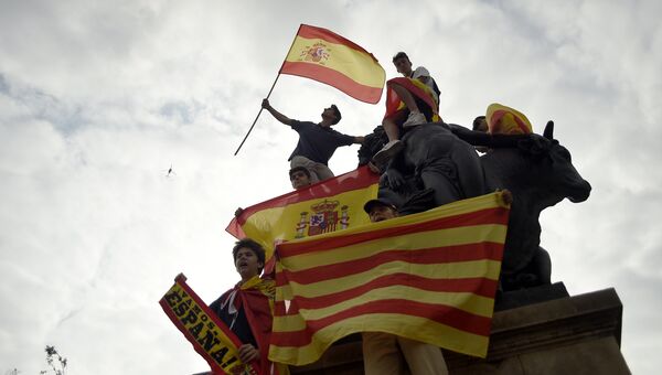 Протестующие с флагами Испании и Каталонии во время демонстрации в Национальный день Испании в Барселоне