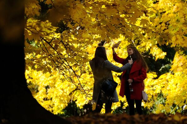 Девушки фотографируются в Коломенском парке в Москве