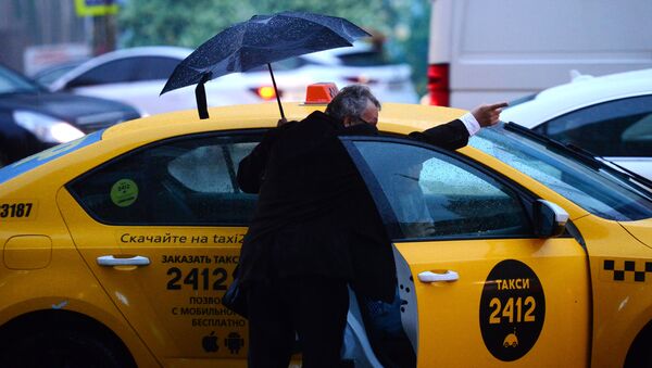 Мужчина у автомобиля такси в Москве во время дождя. Архивное фото