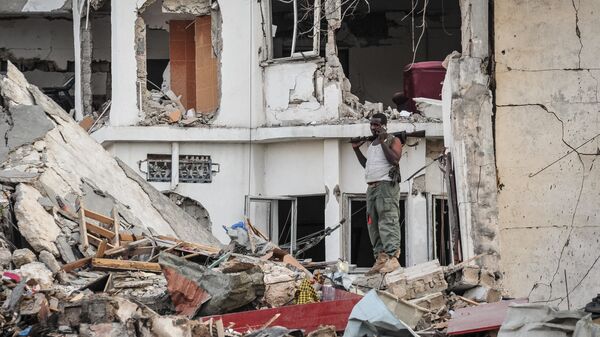 Сомалийский солдат стоит на месте взрыва. Архивное фото