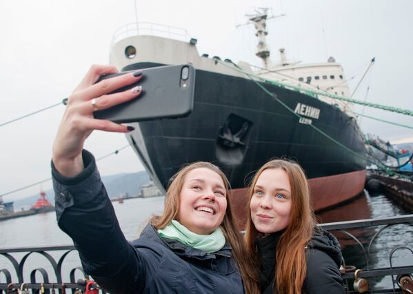 Девушки фотографируются перед музеем-ледоколом Ленин в Мурманске